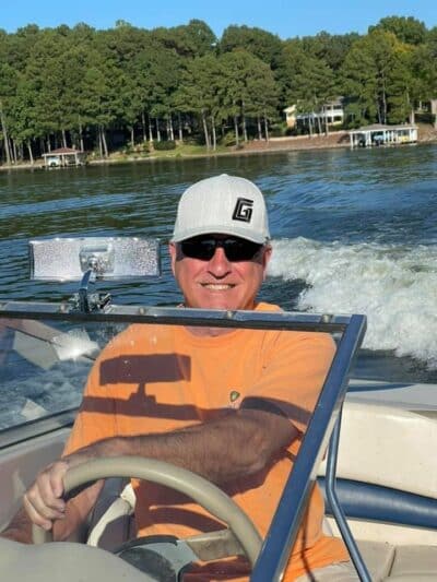 Bruce Swagler piloting a boat on a lake.